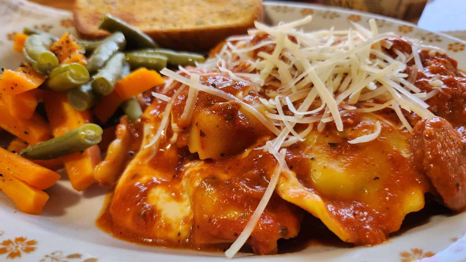 Pasta skillet plated with fresh vegetables and garlic bread